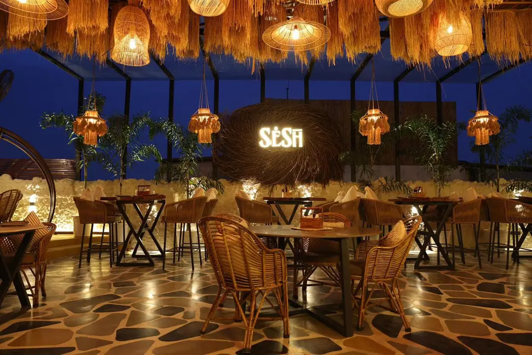 SESH rooftop restaurant at night under woven pendant lights